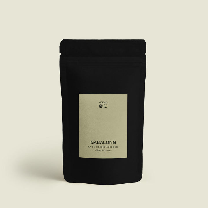 Verpackung von Gabalong Tee mit Etikett, abgebildet vor einem beruhigenden Hintergrund, der die entspannende und ausgewogene Natur dieses Tees widerspiegelt.
Packaging of Gabalong Tea with label, shown against a calming background that reflects the relaxing and balanced nature of this tea.