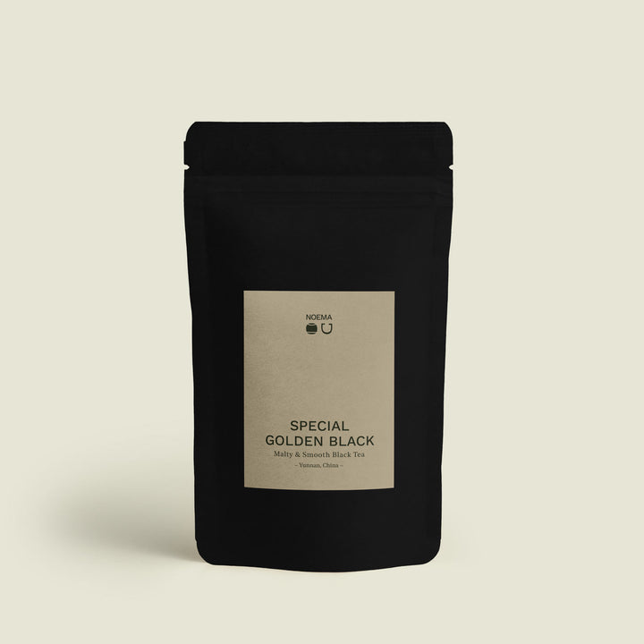Verpackung des Special Golden Black Tees mit Etikett, das den tiefen, malzigen Geschmack des Tees aus den Hochlagen Yunnans, China, präsentiert.
Packaging of Special Golden Black Tea with label, showcasing the deep, malty flavor of the tea from the highlands of Yunnan, China.