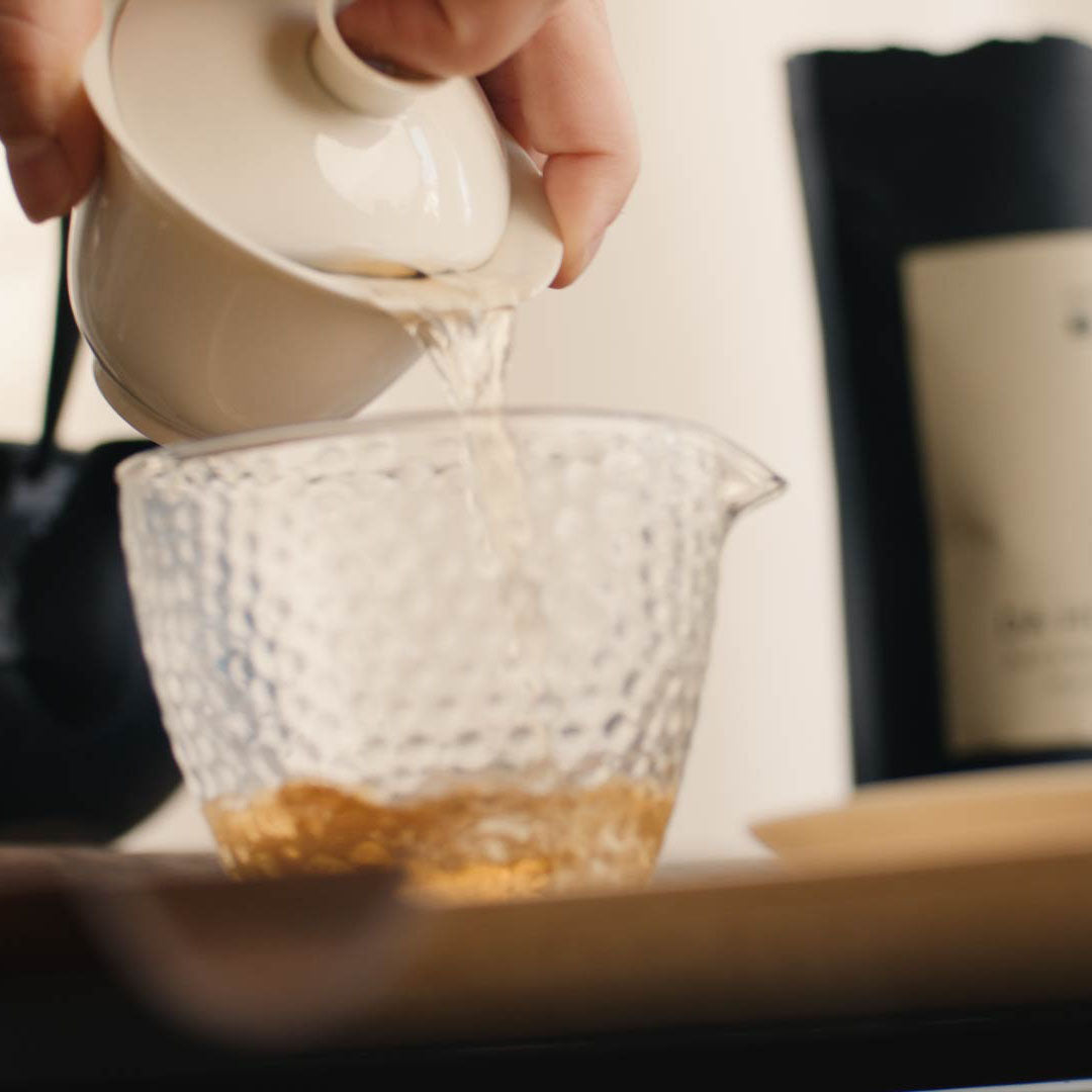 Weißer Tee Da Hong Pao wird in Tasse eingeschenkt, goldene Farbe