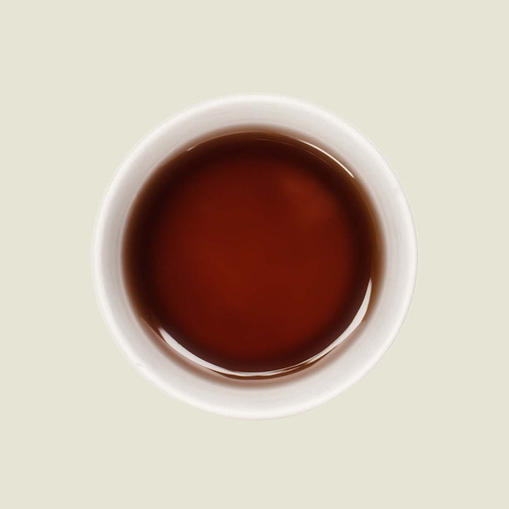 Tasse Da Hong Pao Tee mit tiefem, bernsteinfarbenem Teefarbton, der die komplexe und vollmundige Natur dieses Tees widerspiegelt.

Cup of Da Hong Pao tea with deep amber tea color reflecting the complex and full-bodied nature of this tea.