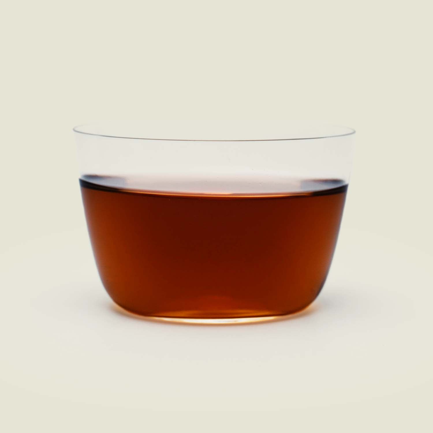 Da Hong Pao – Das seitliche Glas zeigt die tiefe, rötliche Farbe dieses kräftigen Oolong-Tees, der komplexe, erdige Aromen entfaltet.

Da Hong Pao – The side view of the glass reveals the deep, reddish color of this bold Oolong tea, unfolding complex, earthy flavors.