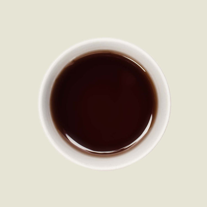 Tasse Darjeeling Grey von oben, mit einem leuchtend bernsteinfarbenen Tee, der die blumigen und zitrusartigen Aromen widerspiegelt.

Darjeeling Grey cup from above, showing the bright amber tea color that reflects its floral and citrus notes.