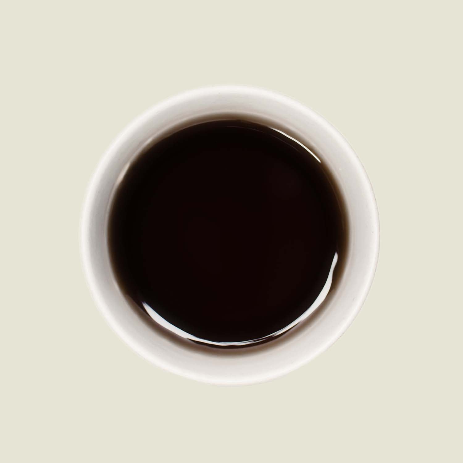 Tasse Keemun OP von oben, mit einer tiefen, goldbraunen Teefarbe, die die charakteristische Komplexität und milden Aromen dieses Schwarztees widerspiegelt.

Keemun OP cup from above, displaying a rich, golden-brown tea color that reflects the characteristic complexity and mild flavors of this black tea.