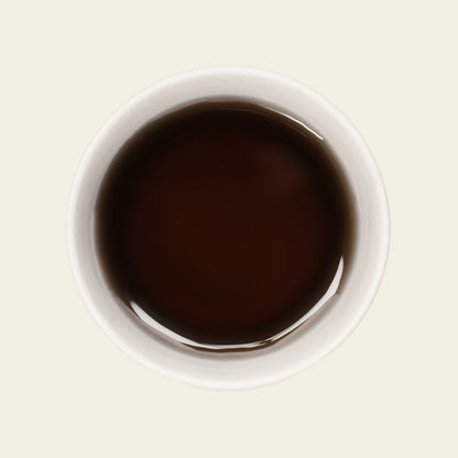 Tasse Oriental Beauty von oben, mit einer goldenen Teefarbe, die die floralen und honigsüßen Aromen dieses einzigartigen Oolong-Tees widerspiegelt.

Oriental Beauty cup from above, showcasing a golden tea color that reflects the floral and honeyed sweetness of this unique Oolong tea.