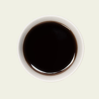 Tasse Pu Erh Chai von oben, mit einer tiefen, rötlich-braunen Teefarbe, die die würzigen Aromen dieses kraftvollen Tees widerspiegelt.

Pu Erh Chai cup from above, showcasing a deep, reddish-brown tea color that reflects the spicy aromas of this robust tea.