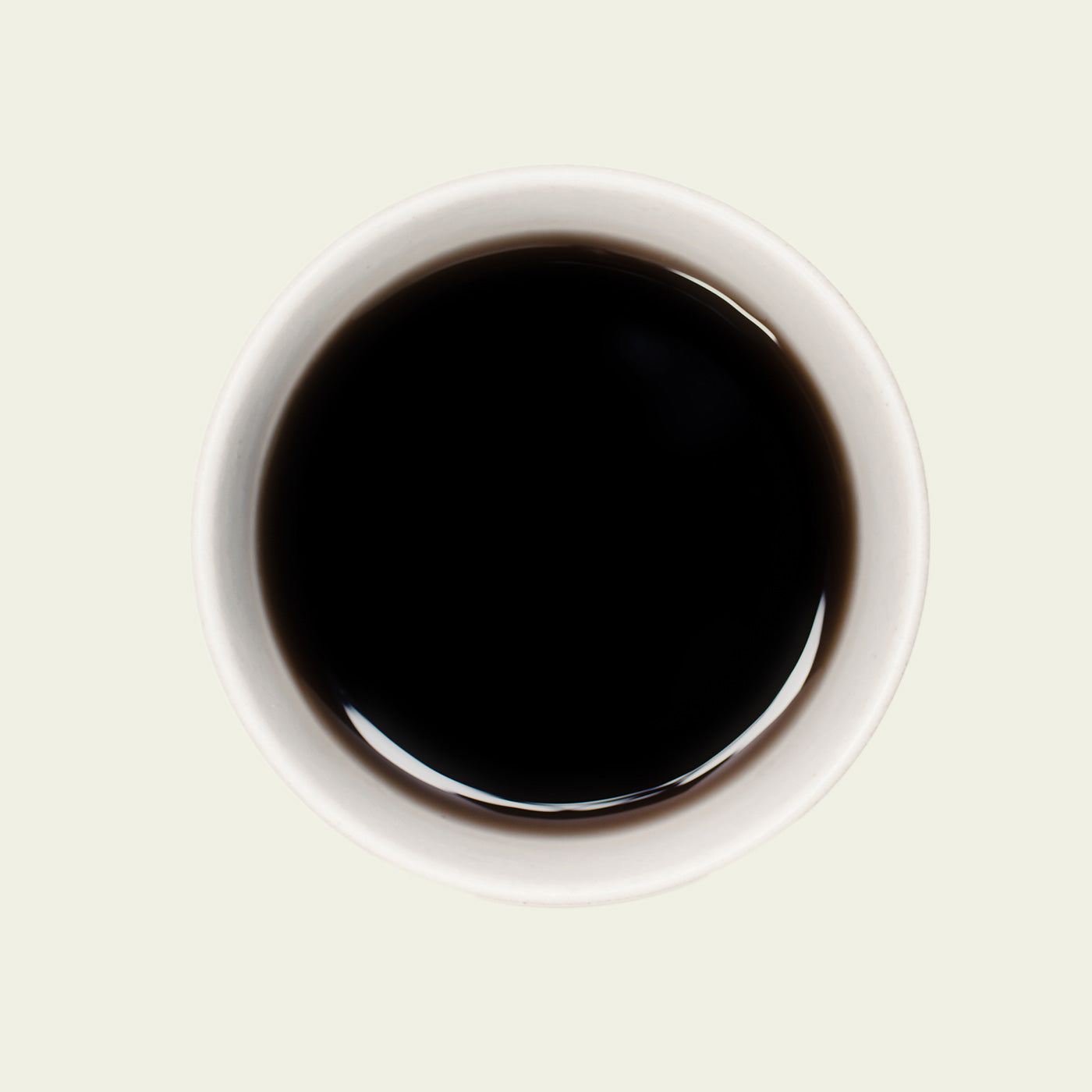 Tasse Pu Erh Menghai Five Years von oben, mit einer tiefen, rotbraunen Teefarbe, die die lang gereiften, komplexen Aromen dieses Tees widerspiegelt.

Pu Erh Menghai Five Years cup from above, showcasing the deep reddish-brown tea color that reflects the long-aged, complex flavors of this tea.