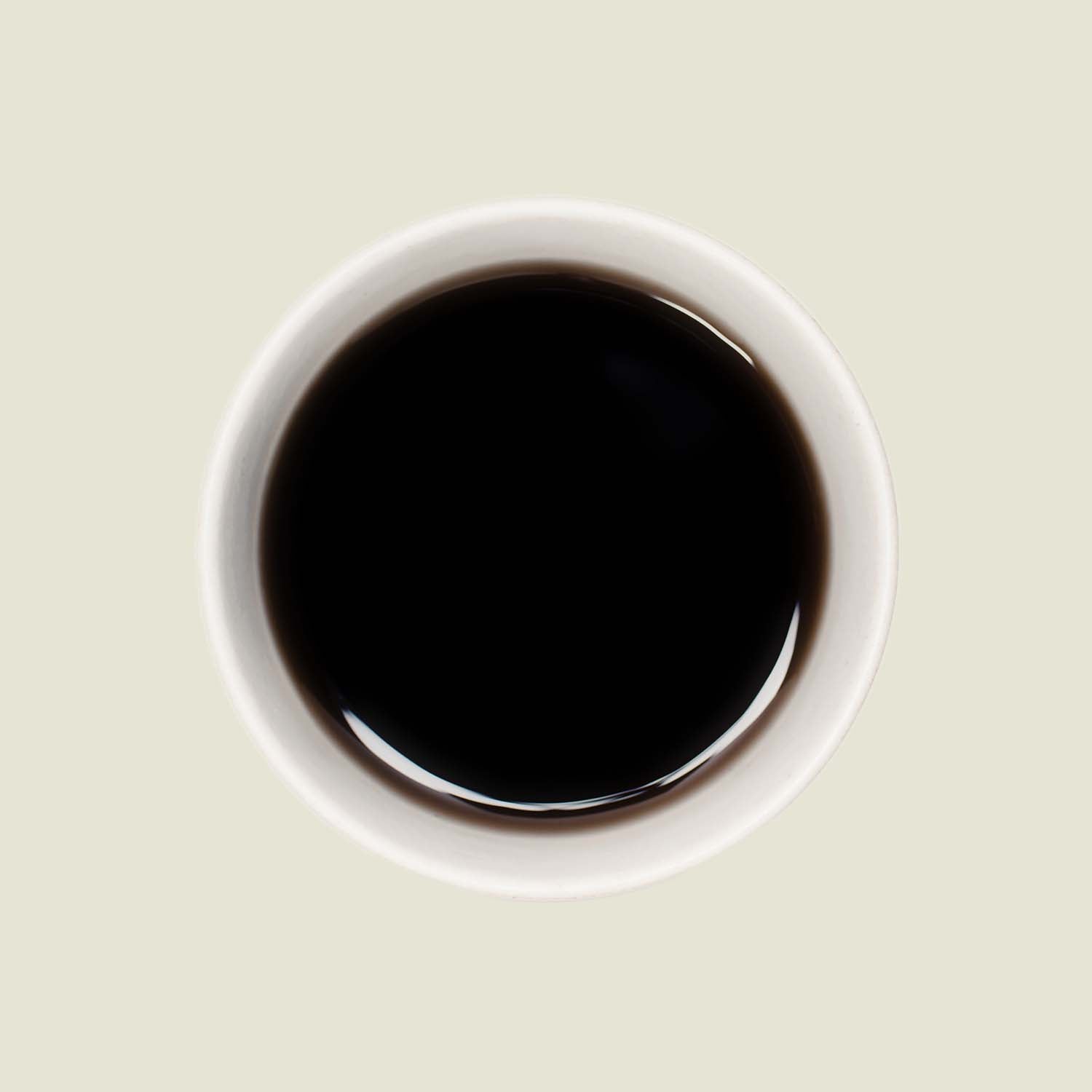 Tasse Pu Erh Menghai Five Years von oben, mit einer tiefen, rotbraunen Teefarbe, die die lang gereiften, komplexen Aromen dieses Tees widerspiegelt.

Pu Erh Menghai Five Years cup from above, showcasing the deep reddish-brown tea color that reflects the long-aged, complex flavors of this tea.
