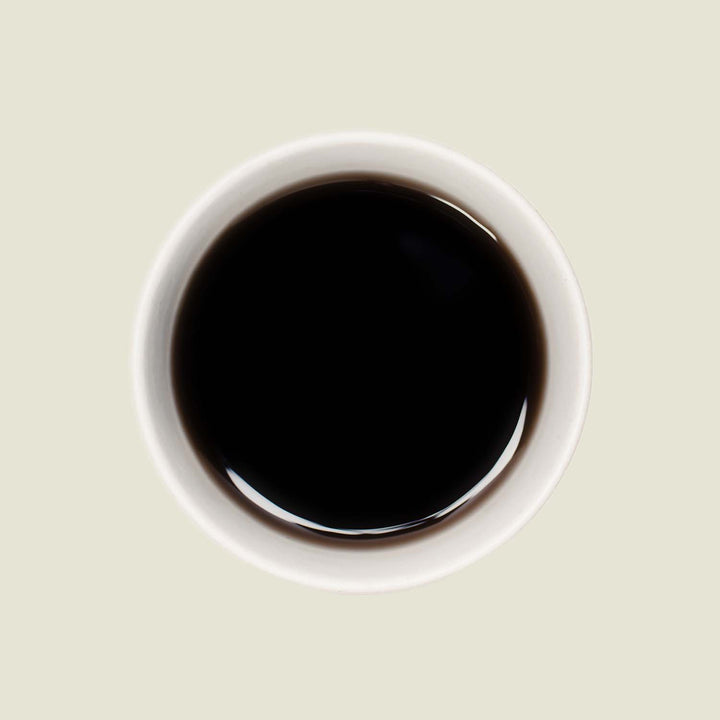 Tasse Pu Erh Menghai Five Years von oben, mit einer tiefen, rotbraunen Teefarbe, die die lang gereiften, komplexen Aromen dieses Tees widerspiegelt.

Pu Erh Menghai Five Years cup from above, showcasing the deep reddish-brown tea color that reflects the long-aged, complex flavors of this tea.