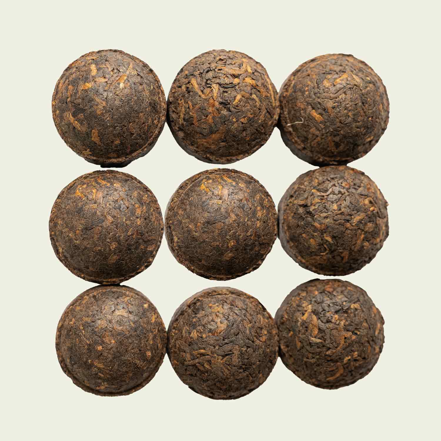 Kleine Pu Erh-Törtchen von oben fotografiert, kompakt gepresst und dunkel – Mini Tuo Cha von Noema.