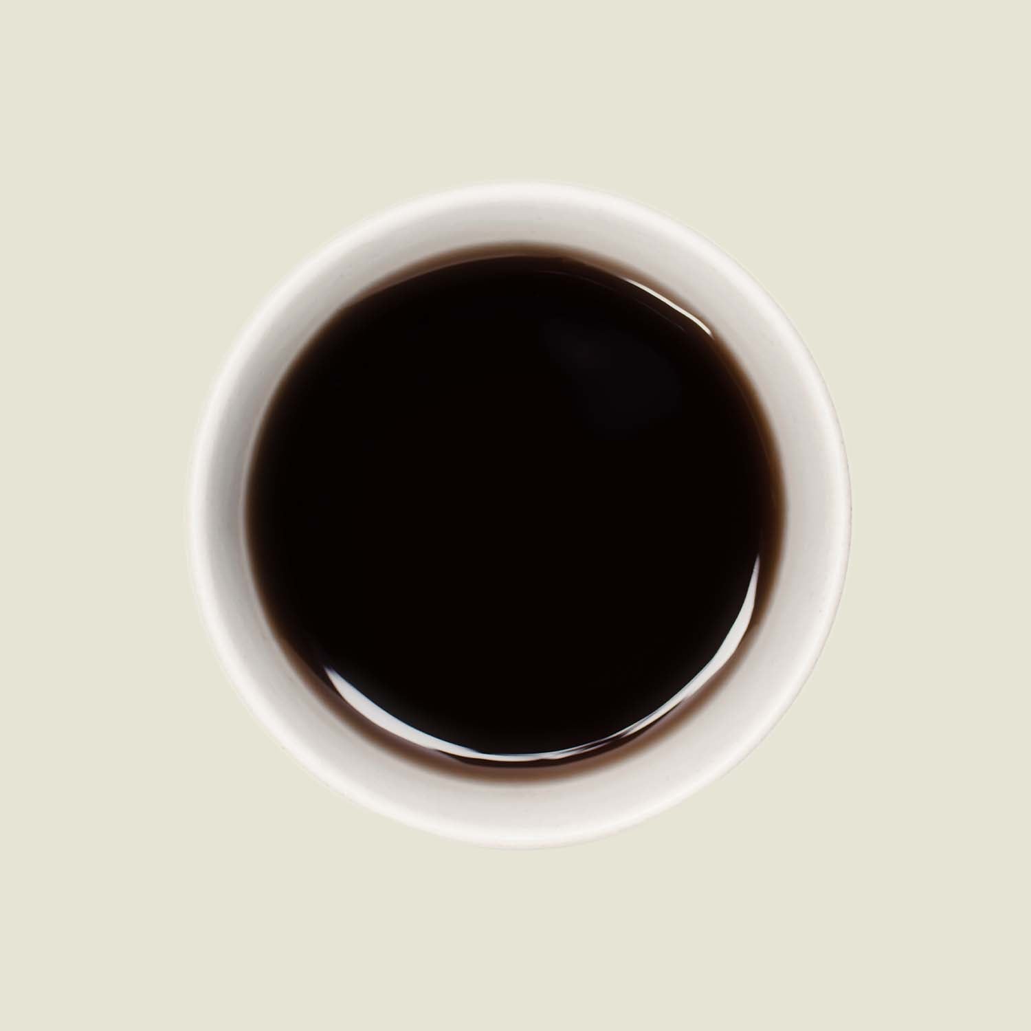 Tasse Pu Erh Mini Tuo Cha von oben, mit einer tiefen, erdigen Teefarbe, die die kräftigen und komplexen Aromen dieses Tees widerspiegelt.

Pu Erh Mini Tuo Cha cup from above, showcasing the deep earthy tea color that reflects the strong and complex flavors of this tea.