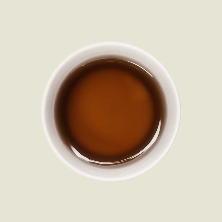 Tasse Silver Pearl Tee mit einer leuchtend gold-grünen Teefarbe, die die florale Eleganz und weiche Süße dieses handgerollten grünen Tees widerspiegelt.

Cup of Silver Pearl tea with a bright golden-green tea color, reflecting the floral elegance and soft sweetness of this hand-rolled green tea.