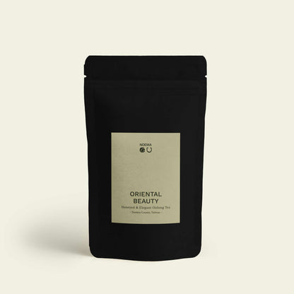 Verpackung von Oriental Beauty Tee mit Etikett, abgebildet auf einem Bild, das die elegante Präsentation des Tees zeigt.

Packaging of Oriental Beauty Tea with label, shown in an image highlighting the elegant presentation of the tea.