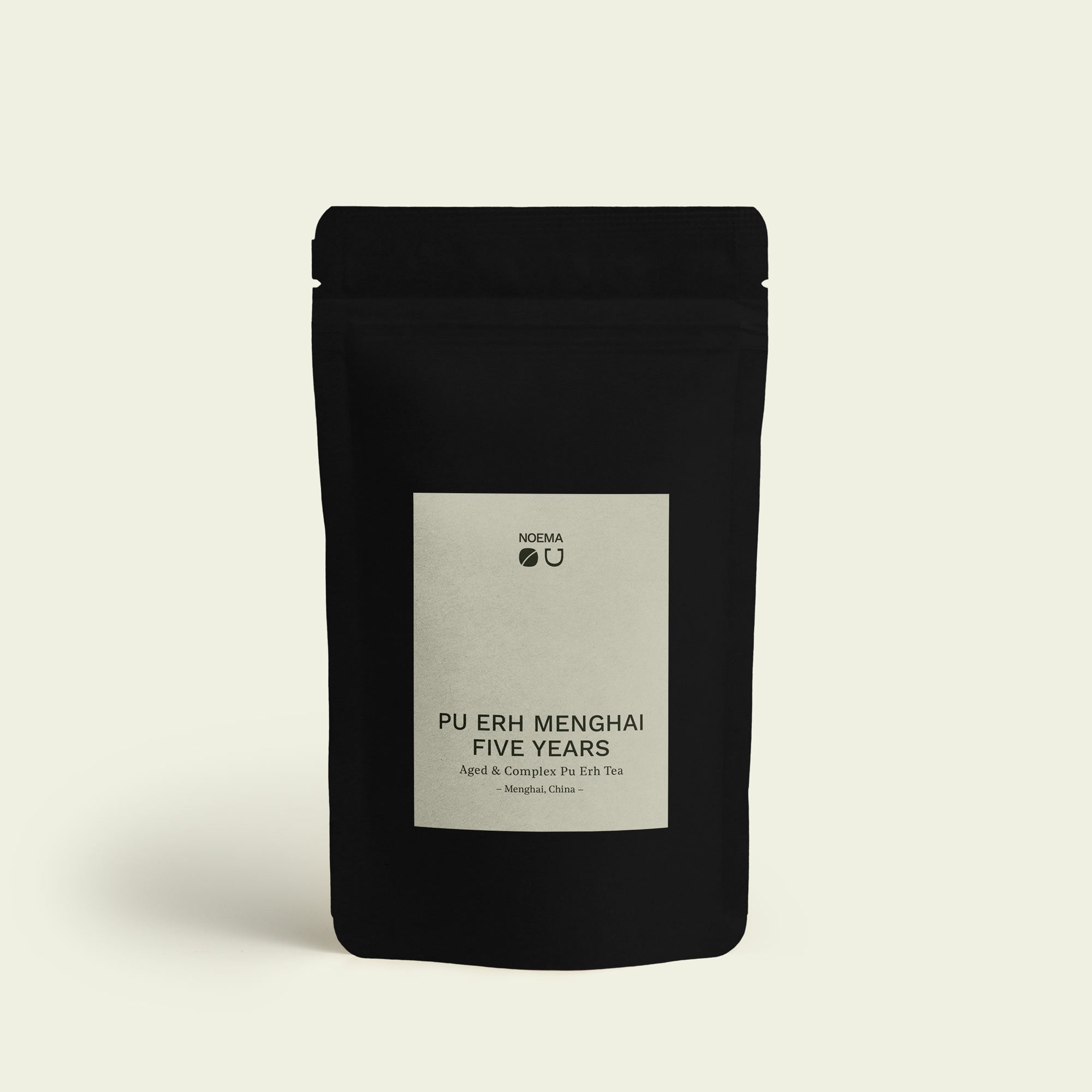 Verpackung des Pu Erh Menghai Five Years Tees mit Etikett, abgebildet vor einem schlichten Hintergrund, der die reiche Tiefe und die lang gereifte Aromen dieses Tees widerspiegelt.

Packaging of Pu Erh Menghai Five Years Tea with label, displayed against a simple background that reflects the rich depth and long-aged flavors of this tea.