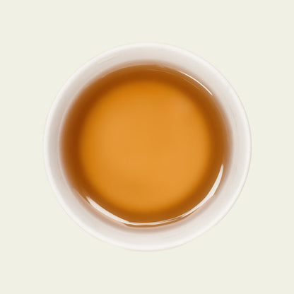 Tasse Tie Guan Yin Tee mit klarer, goldgelber Teefarbe, die die florale und elegante Note dieses Oolong-Tees betont.

Cup of Tie Guan Yin tea with clear golden-yellow tea color emphasizing the floral and elegant notes of this Oolong tea.