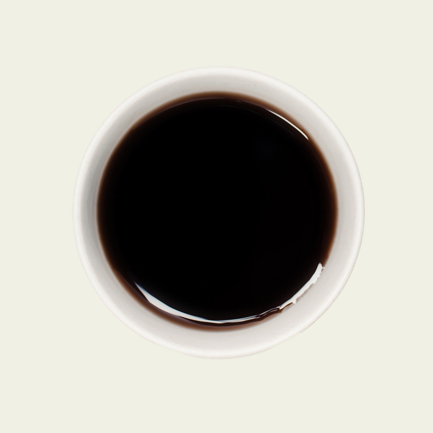 Tasse Yunnan Pu Erh von oben, mit einer tiefen, bernsteinfarbenen Teefarbe, die die reichhaltigen, erdigen Aromen dieses Tees unterstreicht.

Yunnan Pu Erh cup from above, showcasing the deep amber tea color that highlights the rich, earthy flavors of this tea.