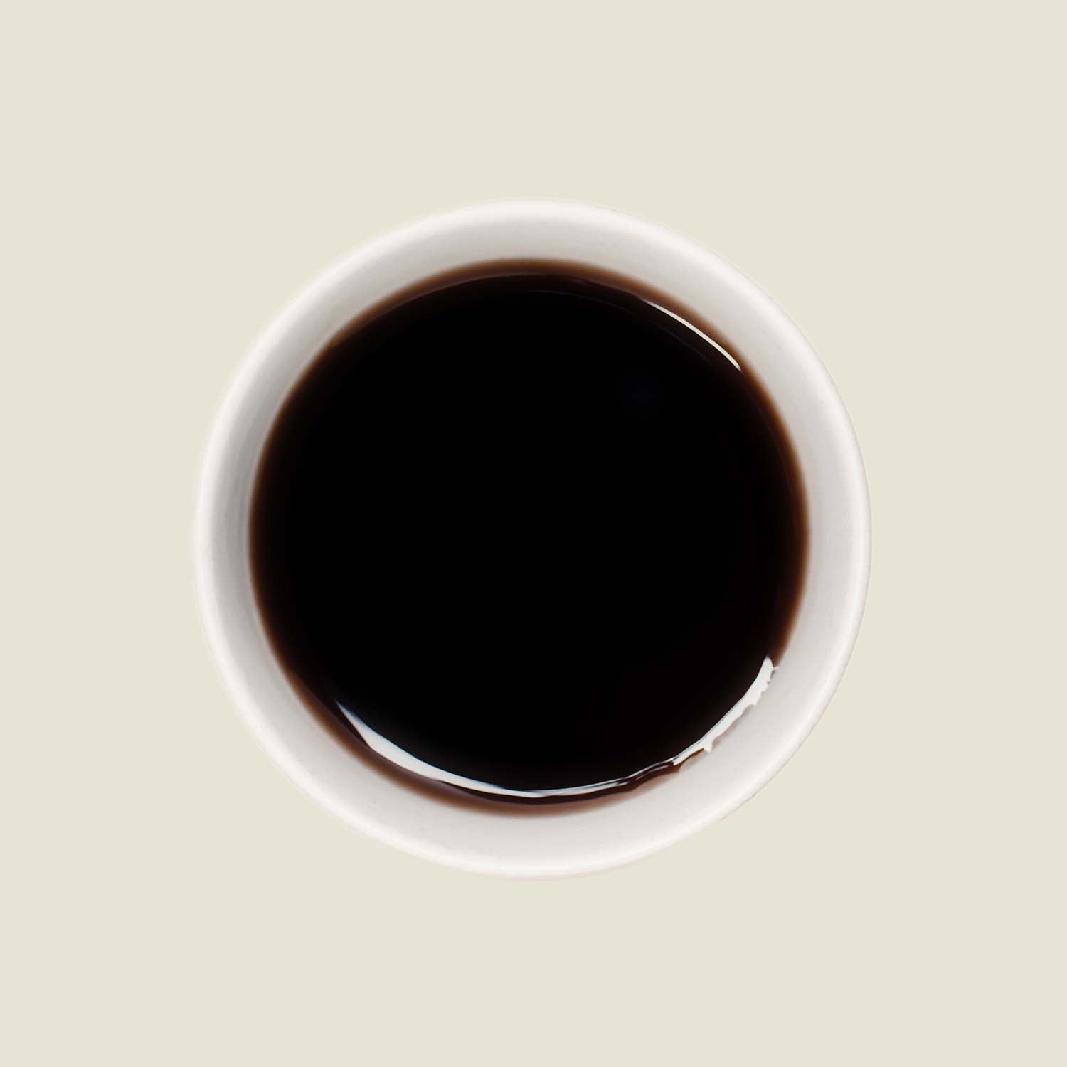 Tasse Yunnan Pu Erh von oben, mit einer tiefen, bernsteinfarbenen Teefarbe, die die reichhaltigen, erdigen Aromen dieses Tees unterstreicht.

Yunnan Pu Erh cup from above, showcasing the deep amber tea color that highlights the rich, earthy flavors of this tea.
