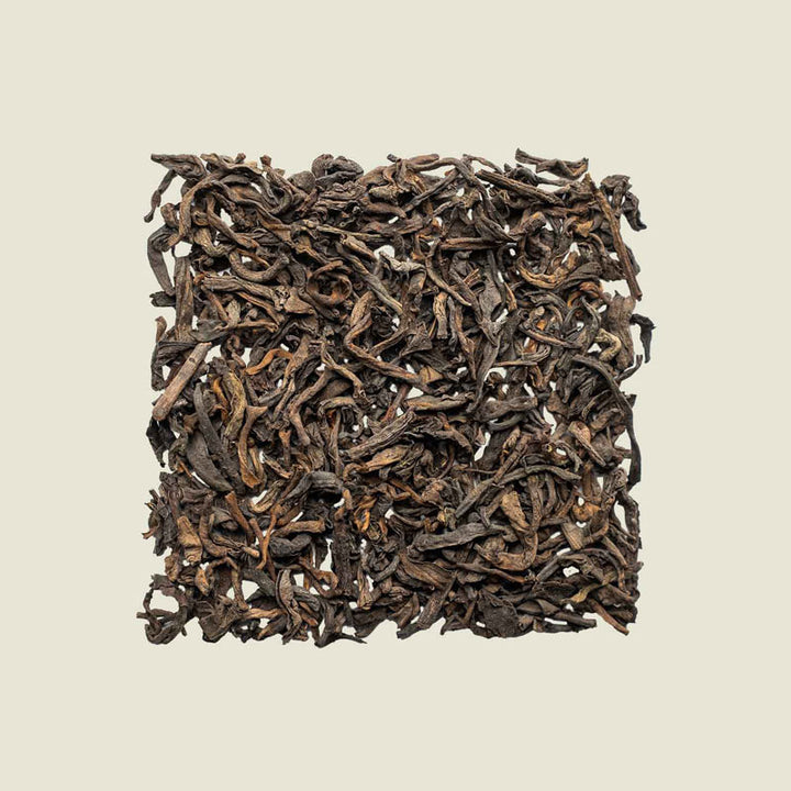Lose Yunnan Pu Erh-Blätter mit erdiger Struktur, Draufsicht auf dunkle Töne – gereifter Tee aus China.