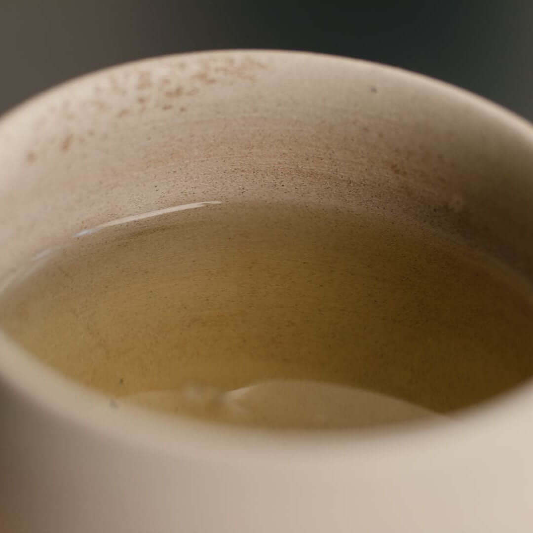 Grüner Tee in Tasse, Nahaufnahme der leuchtenden Teefarbe
