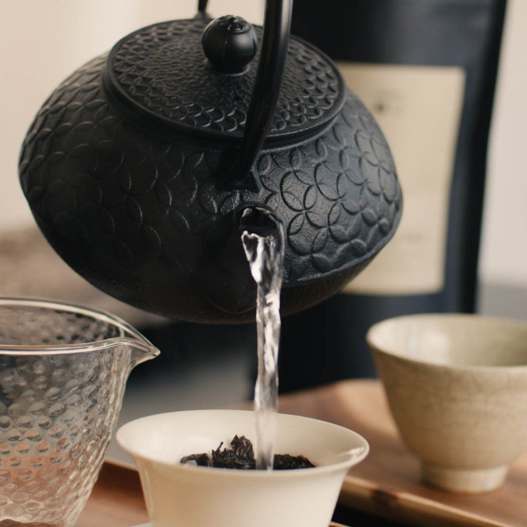Teekanne gießt heißes Wasser in Gaiwan für Da Hong Pao