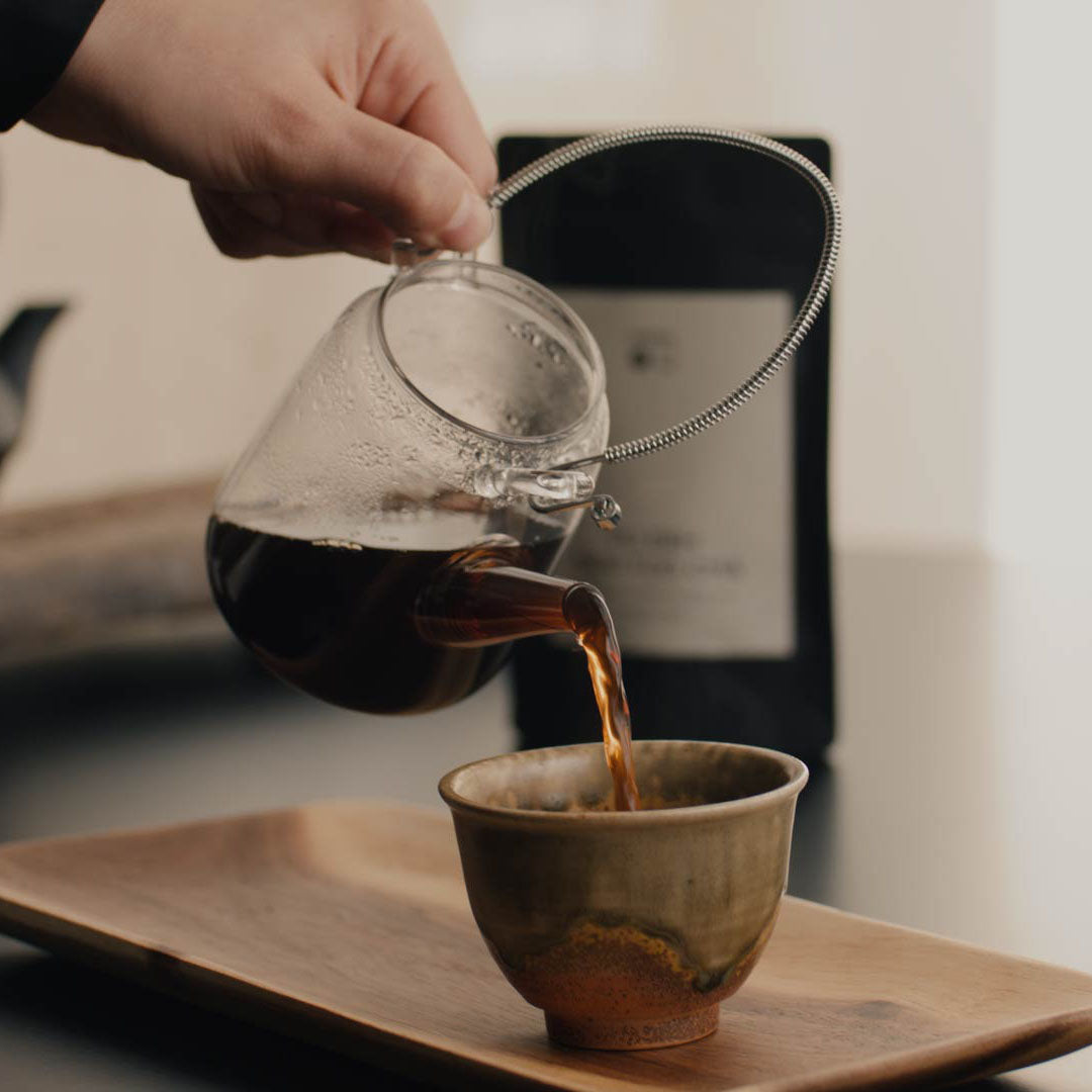 Pu Erh Mini Tuo Chas Tee wird in Tasse eingeschenkt